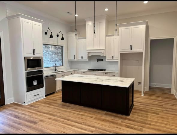 Light wood-look flooring in open living space by AVS Flooring